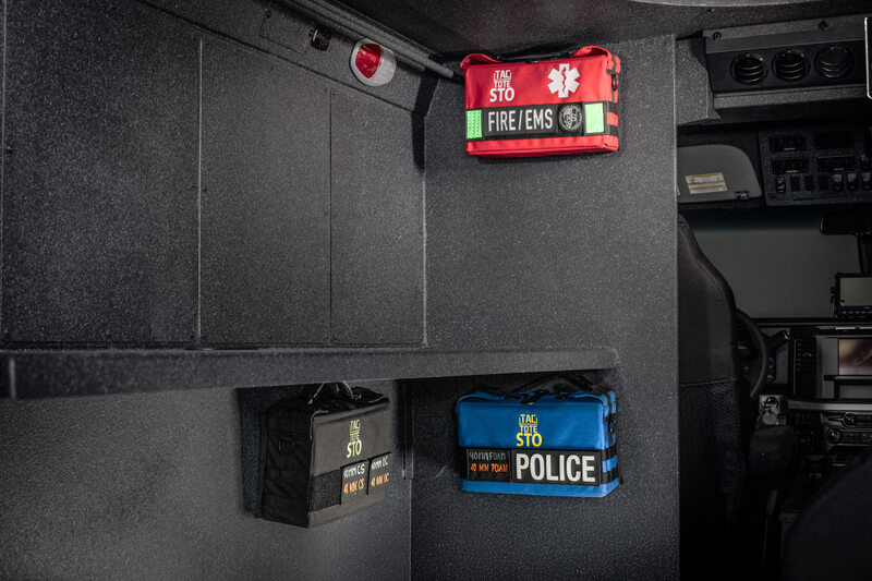 An interior of an armored vehicle with Tac-Tote's black STO bag, red Med STO bag, and blue less lethal STO bag. 